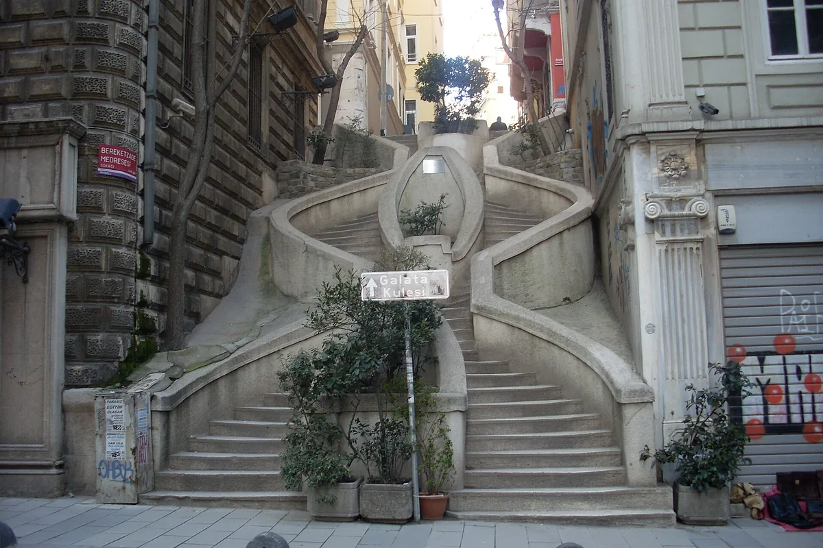 De svängda tvillingtrapporna i Camondo-trappan i Galata, med stenbalustrad och krukor med växter.