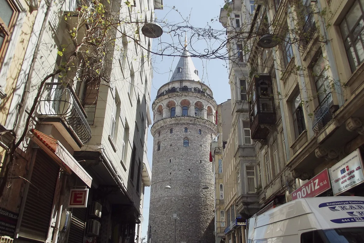 Galatatårnet som reser sig över en smal gata i Beyoğlu mellan gamla hyreshus.